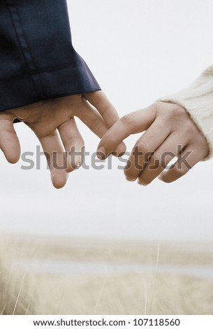 a young couple holding hands, outdoors