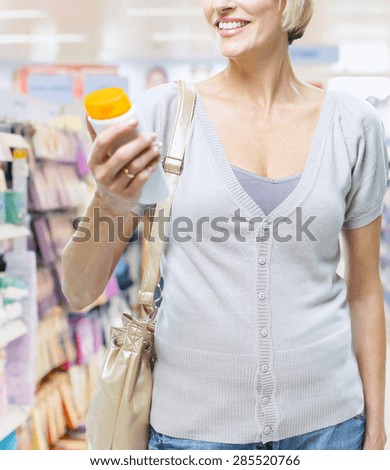 woman chooses shampoo in large store