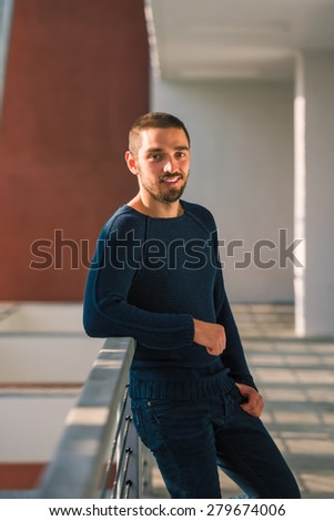 Handsome sexy and casual young man standing near balcony. High resolution photo.