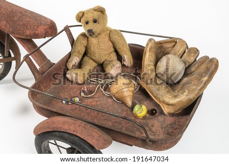 Close view of abandoned childhood toys Riding in a rusted red cart you find my old treasured toys
