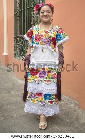 Colorful Mayan girl in Yucatan This native woman from the city of Merida in Yucatan, Mexico poses gladly to show its vibrant dress sewn by hand in a very colorful fashion.