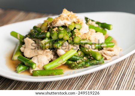 Freshly prepared Asian style chicken and asparagus stir fry with garlic
