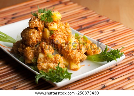 Thai fried calamari appetizer garnished with fresh pineapple chunks.