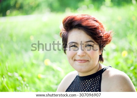 Smiling attractive brunette woman under soft natural lighting. Shallow depth of field.