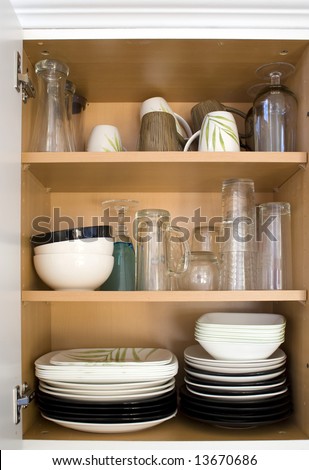 A cabinet full of plates, glasses, and dishes.