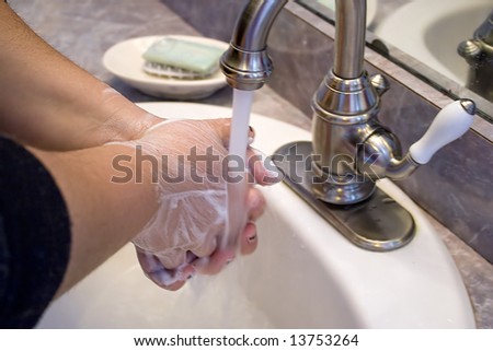 A Person Washing And Rinsing Off Their Hands In The Bathroom Sink ...