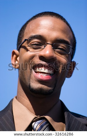 African American man wearing glasses and a business suit isolated over a blue sky background.