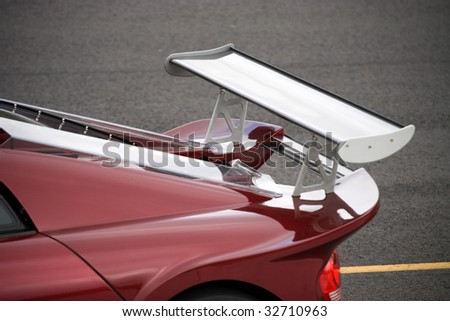Closeup detail of a custom racing spoiler on the rear of a sports car.  Shallow depth of field.