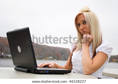 A beautiful young blonde woman in a mobile business setting with her laptop.