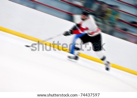 Abstract motion blur of a hockey player handling the puck as he speeds down the ice.