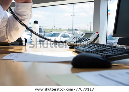Close up of a modern office workplace desk setup with a computer mouse keyboard and phone. Shallow depth of field.