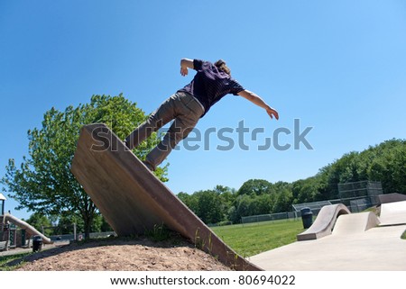 Action shot of a skateboarder going up a concrete skateboarding ramp at the skate park.