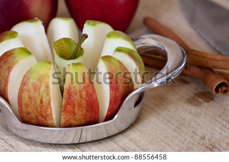 An apple is sliced into wedges and cored using a handy kitchen tool.