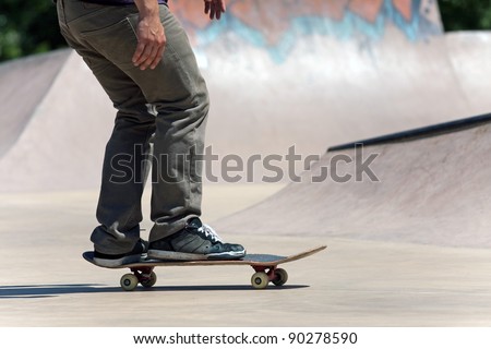 Action shot of a skateboarder skating at the skate park with concrete ramps.