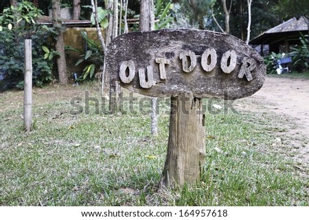 Old weathered wood sign with out door text.