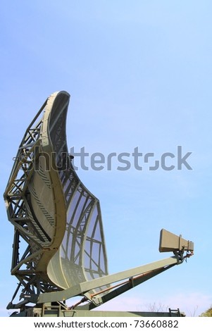 Military radar dish against blue sky