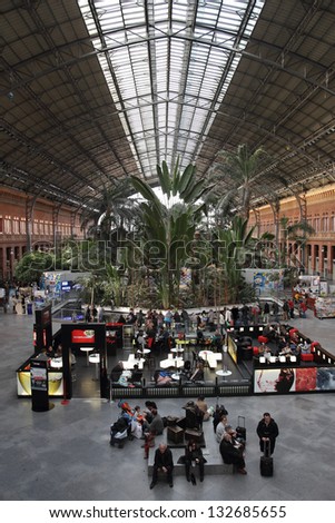 MADRID - MARCH 2: people crowded the interior plaza of Puerta de Atocha Railway Station on March 2, 2013 in Madrid, Spain. Puerta de Atocha is the largest railway station in Madrid.