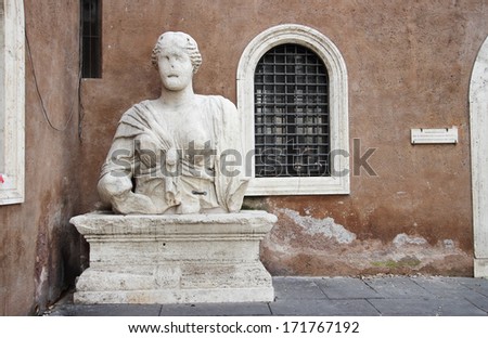 ROME, ITALY - JANUARY 11, 2014: Soprintendenza BSAE Cultural Heritage and Activities palace at San marco square with the huge 3 metres high Madama Lucrezia statue (ancient Roman Bust)