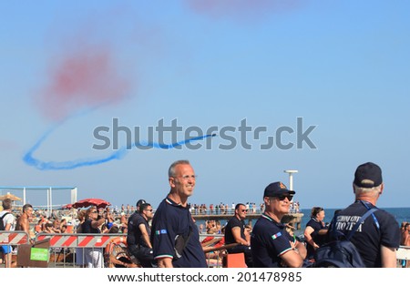 ROME, ITALY - 28 JUNE, 2014: People assist at the Patrouille de France show during the Rome International Air Show. Event held in Ostia beach
