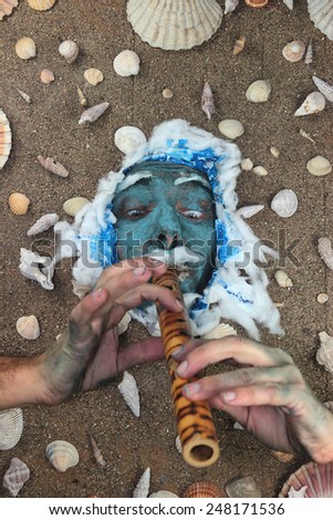Blue sea man playing flute underwater