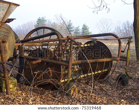 dilapidated old farm machinery in a rural landscape