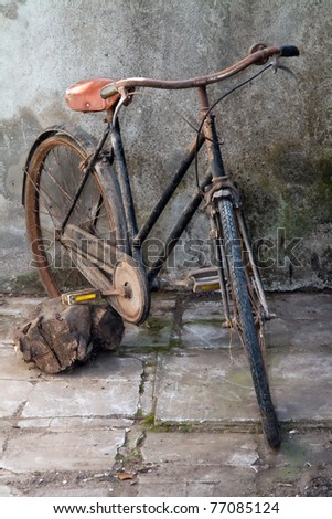 Old bicycle against a dilapidated wall