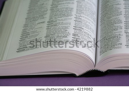 The thick open book lays on a purple background