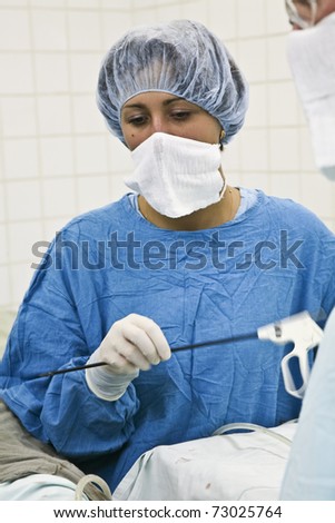 Young surgical nurses delivers instrument the surgeon during surgery