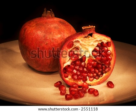 Pomegranate sliced on plate with dark background