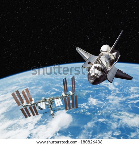 The Space Shuttle and International Space Station above the Earth, with stars in the Background. Elements of this image furnished by NASA.
