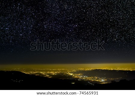 The Universe above city lights. The dark night sky.