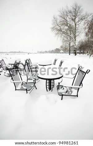 Chairs and table in park cowered with snow