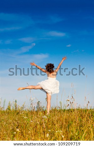 Carefree adorable girl with arms out in field. Summer. Freedom andjoy concept