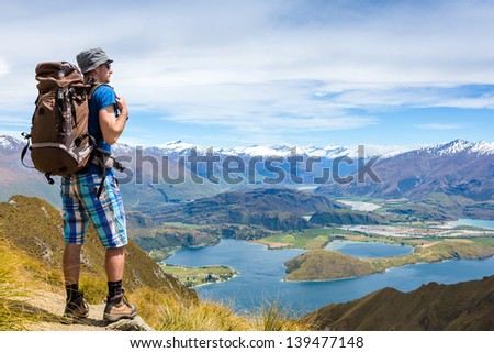 portrait of hiker looking at the horizon in the mountains on sunny day