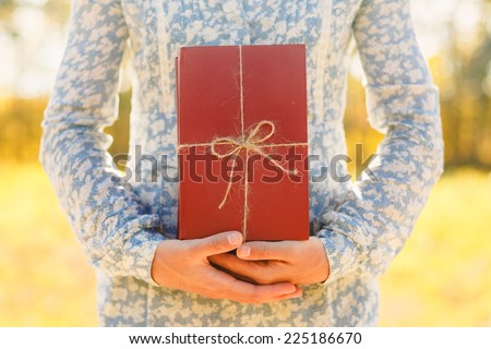 woman holding stacked books with ribbon. Education, reading, inspiration concept