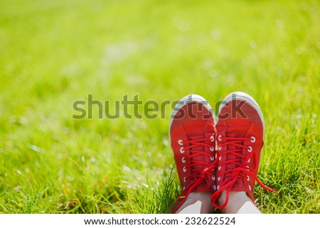 Feet in sneakers in green grass. Summer/lifestyle concept