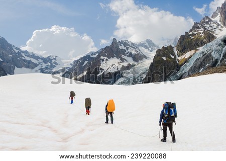 Climbers go up on the glacier with beautiful mountain landscape
