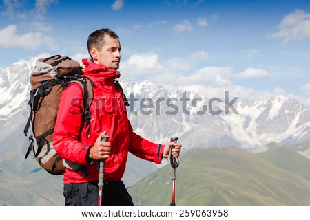 Successful man mountain hiker with backpack on the top of mountains