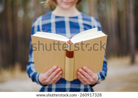 young beautiful women holding open book in hands