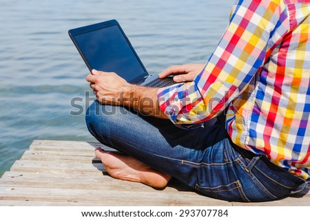 Young man with laptop working outdoor