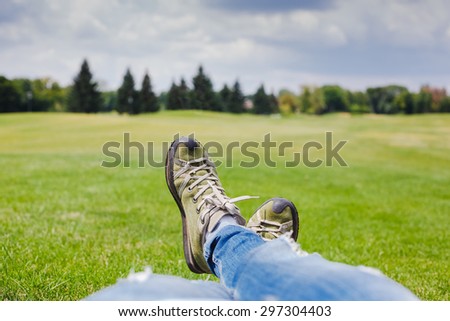youth sneakers on girl legs on grass. summer day