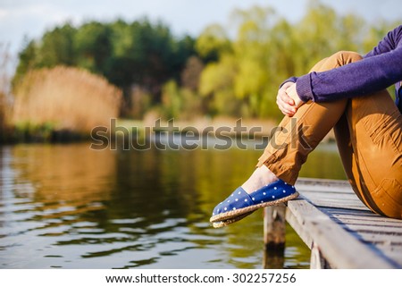 Sitting Woman\'s feet in a sneakers on nature