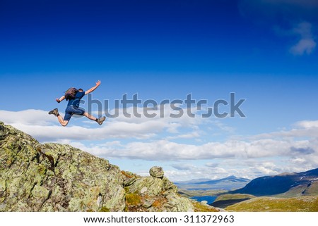 Beautiful mountain landscape with sportive jumping man
