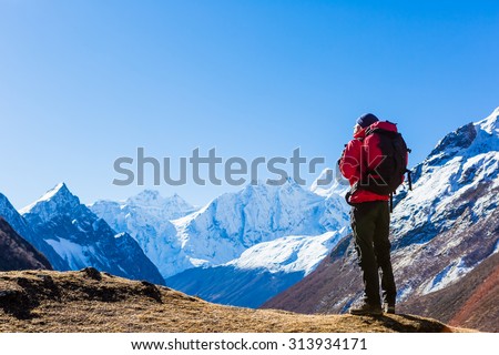 Hiker with backpack standing on top of a mountain and enjoying. Himalayas