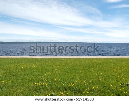 Lake, the sky and grass. Petrozavodsk, Russia, Karelia