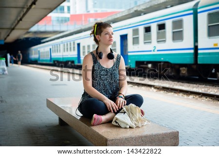 beautiful stylish modern young woman waiting train at the station