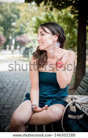 beautiful woman sitting in the bench in city