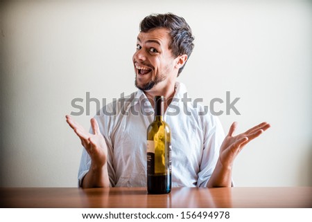 drunk young stylish man with white shirt behind a table