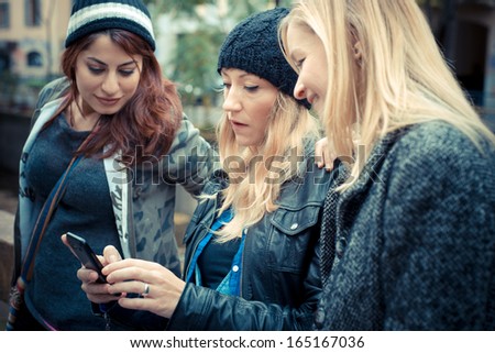 three friends woman on the phone in the street