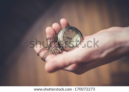 close up of hands with vintage pocket watch retro